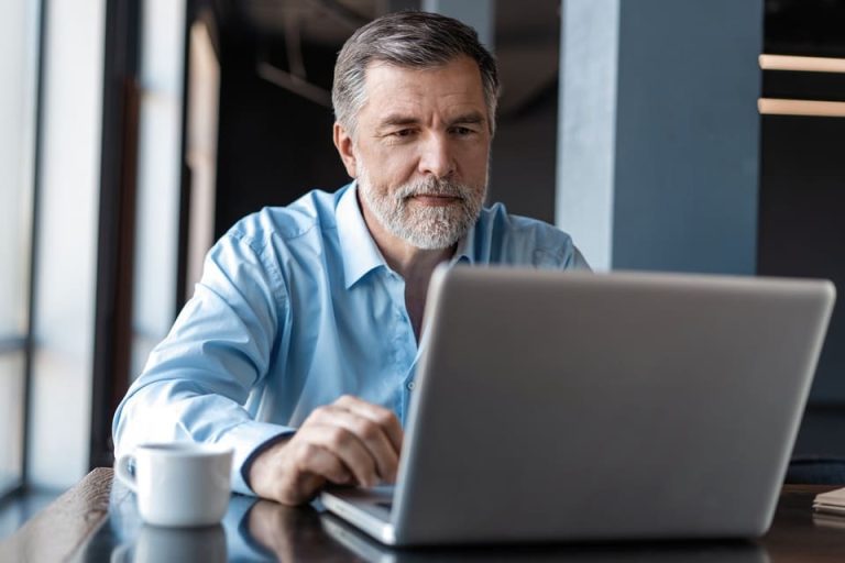 retraité qui consulte son ordinateur